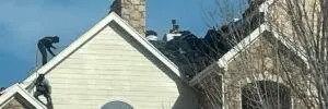 Roofers work on a steeply pitched residential roof during replacement, highlighting how roof pitch impacts roof replacement cost. Denver experts at Elite Roofing & Solar demonstrate safety and precision on complex roof structures.
