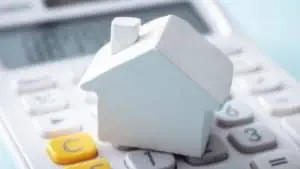 Roof financing image with a calculator and small house.